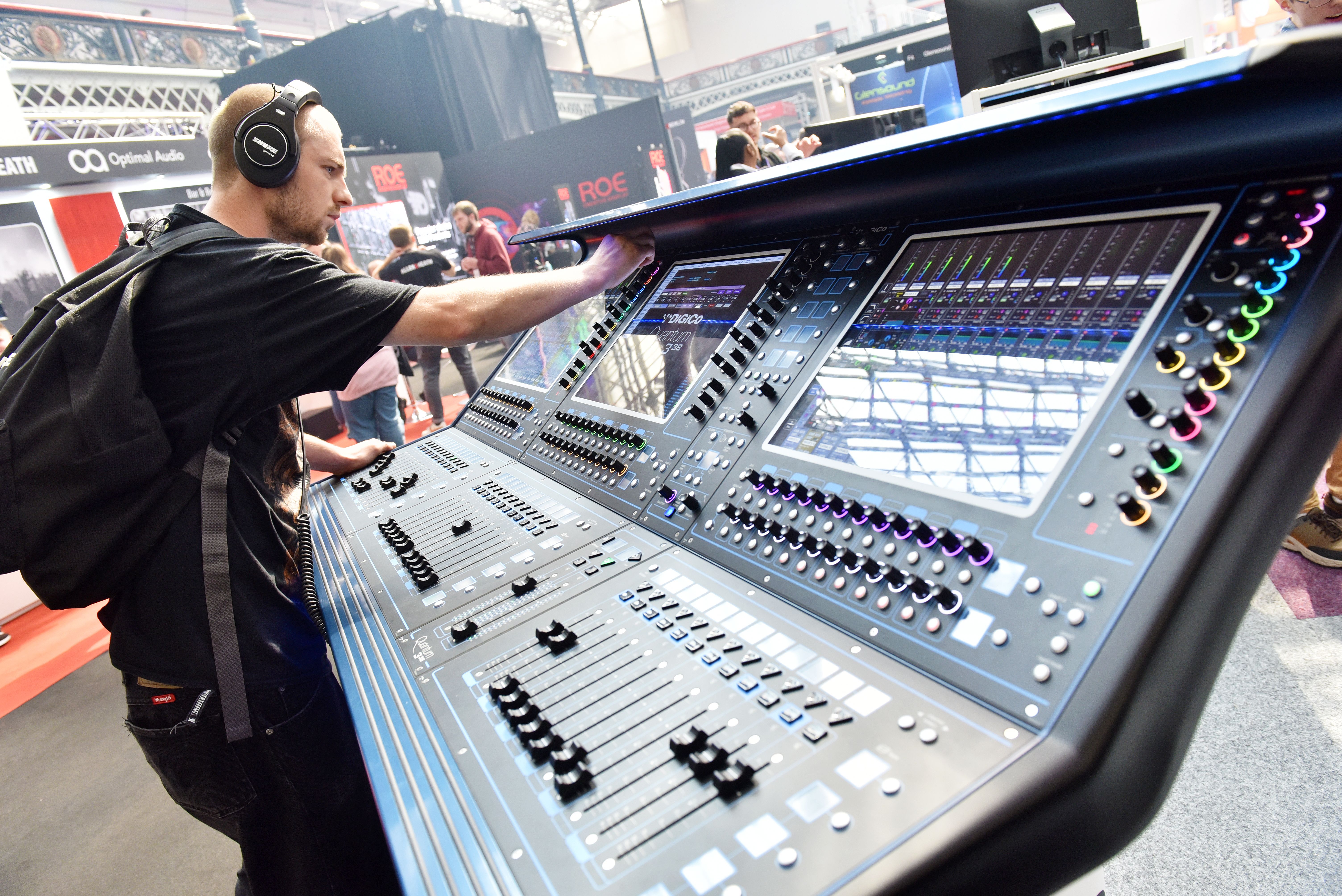A sound engineer trying out a DiGiCo sound desk and Shure headphones  at PLASA Show 2022